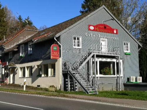 ラーデヴォルムヴァルトにあるHotel Radevormwaldの赤い車が上に乗った灰色の建物