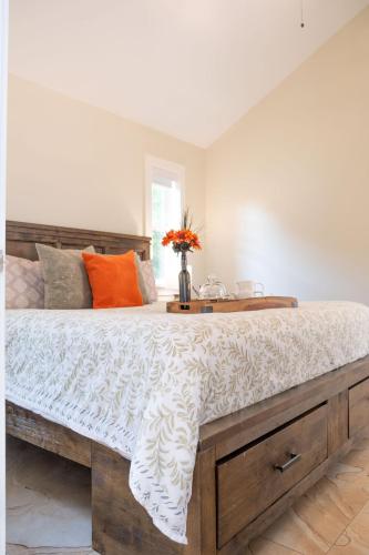 a bedroom with a large wooden bed with orange pillows at Kelowna Bed & Breakfast - CHATHAM HOUSE in Kelowna