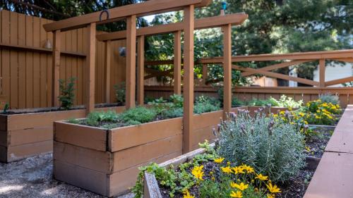 a garden with raised beds in a fence at Kelowna Bed & Breakfast - CHATHAM HOUSE in Kelowna