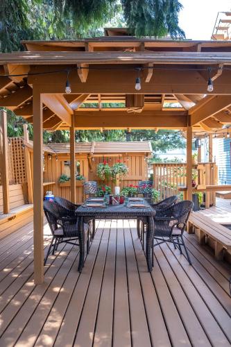 a patio with a table and chairs on a deck at Kelowna Bed & Breakfast - CHATHAM HOUSE in Kelowna