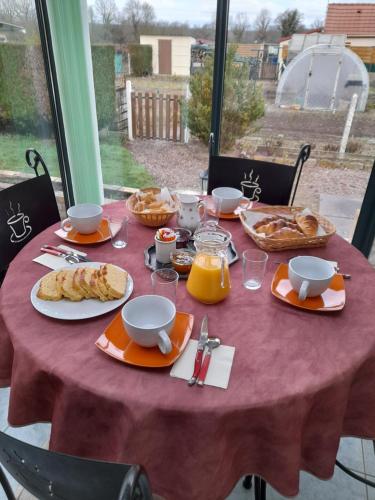 une table avec un tissu de table rouge et de la nourriture dans l'établissement la chaume, à Laugère