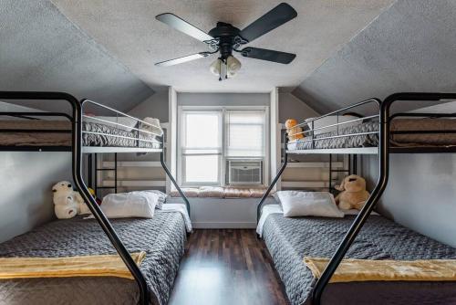 two bunk beds in a room with a ceiling fan at Pet Friendly - Large Families - Heart of Royal Oak - 5 Smart TVs in Royal Oak
