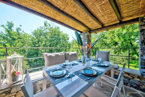 uma sala de jantar com uma mesa e cadeiras numa varanda em I Giardini di Camogli - VILLA SÀRVIA, garden&pool em Camogli