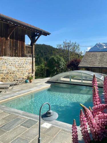 une piscine devant une maison dans l'établissement La Ferme des Cousines, à Saint-Sigismond