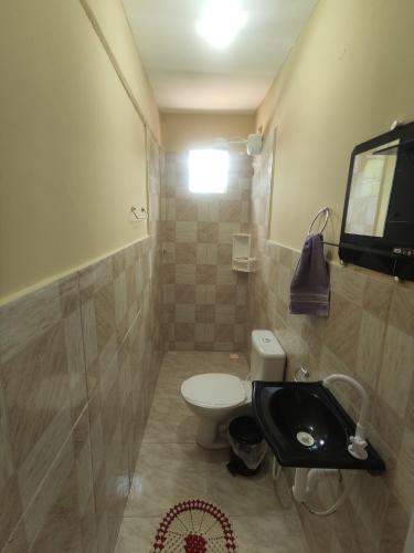 a small bathroom with a toilet and a sink at Aconchego da Nina in Jijoca de Jericoacoara