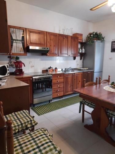 cocina con armarios de madera y mesa de madera con mesa en Appartamento Domusnovas, en Domusnovas