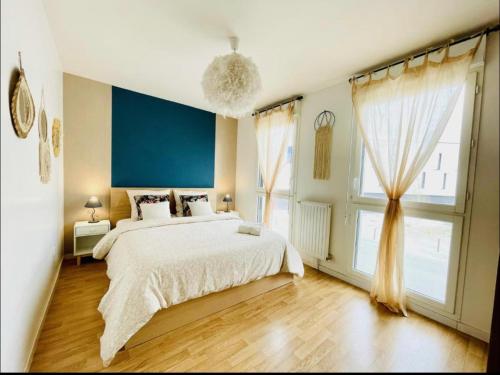 um quarto com uma cama grande e uma janela grande em Joli appartement Proche Disney em Chanteloup En Brie