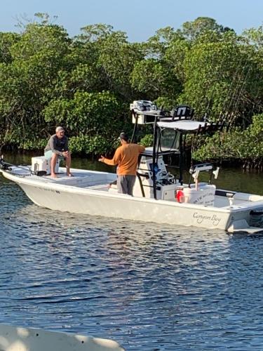 two men on a white boat on the water at Pirates Pointe Resort in Ruskin