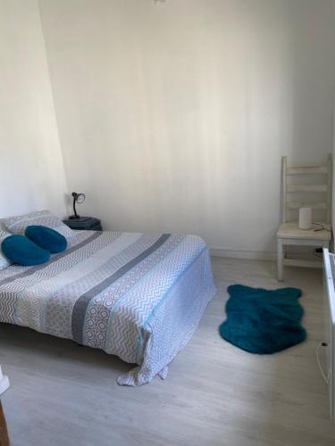 a bedroom with a bed with blue pillows and a chair at Adorable Gesthouse avec parking gratuit sur place. in Le Chêne