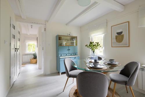 a dining room with a glass table and chairs at Przytulny apartament SUDECKI KLIMAT by SpaceApart in Szklarska Poręba