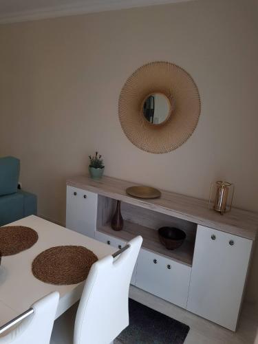 a dining room with a table and chairs and a mirror at Apartamento Alagoinha by Umbral in Vila Nova de Milfontes