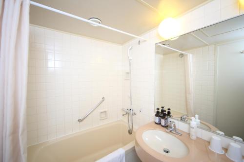 a bathroom with a tub and a sink and a bath tub at Hotel International House Osaka in Osaka