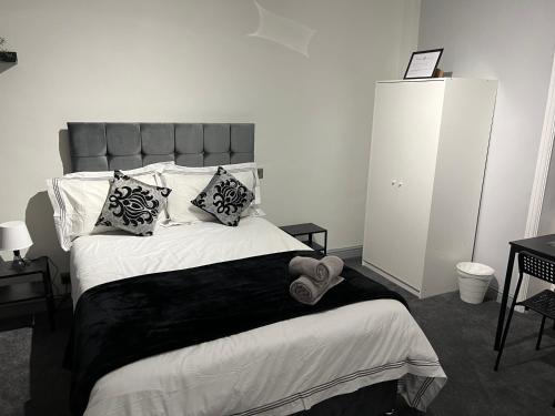 a bedroom with a large bed with a black blanket and pillows at Huddersfield Central Lodge in Huddersfield