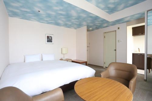 a bedroom with a bed and a table and chairs at Hotel International House Osaka in Osaka