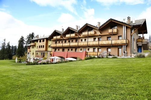 un grand bâtiment avec un champ vert en face dans l'établissement Hotel La Chance, à Pila