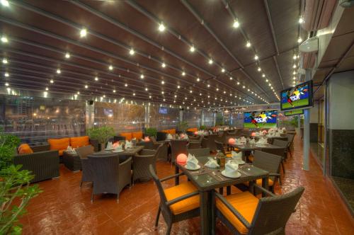 a restaurant with tables and chairs and a television at Sunday Marina View Hotel Apartments in Dubai