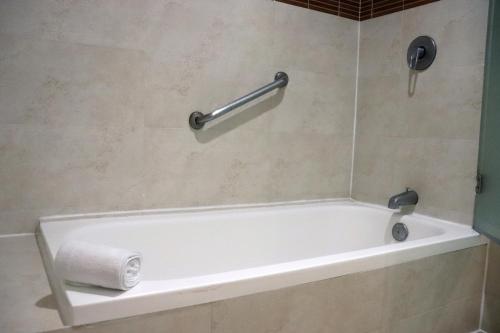 a white bath tub in a bathroom with a towel at Hotel Rio 1300 in Cuernavaca