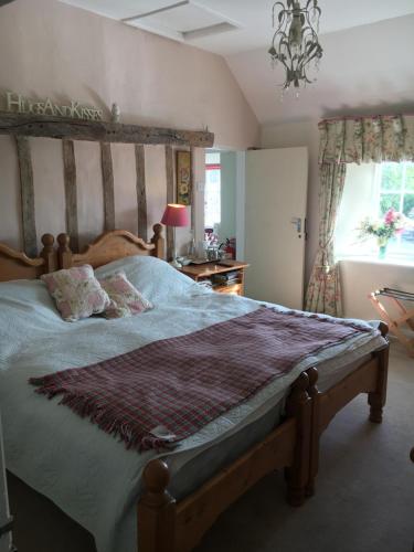 a bedroom with a large bed with a wooden headboard at Higher Biddacott Farm in Chittlehampton