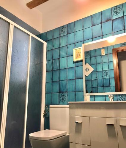 a blue tiled bathroom with a toilet and a sink at Alto Palancia Calle Progreso 25 Sot de Ferrer in Sot de Ferrer