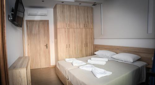 una camera da letto con un letto e asciugamani di Seaside Luxury Apartments Kremasti a Kremasti