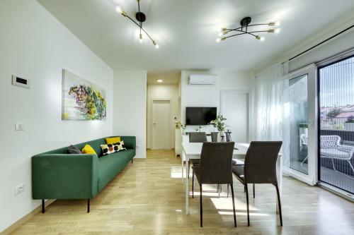 Una sala de estar con un sofá verde y una mesa. en Apartment Alegria Zadar, en Zadar