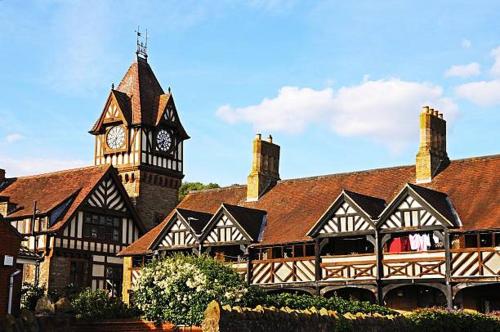 a large building with a clock tower and a building at Tilly's a perfect apartment in the Market Town of Ledbury in Ledbury