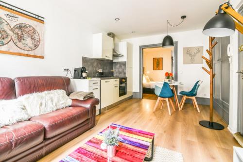 un salon avec un canapé et une cuisine dans l'établissement Parking - Le Wild Forest - Centre Historique, à Phalsbourg