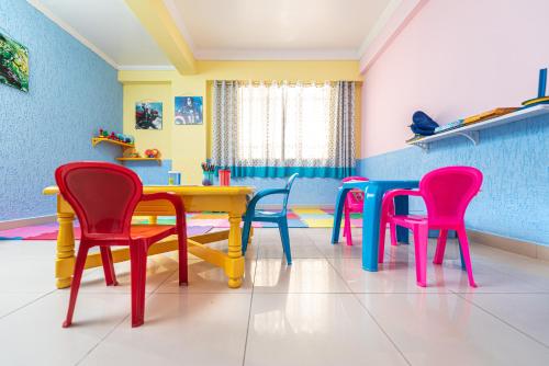 a dining room with colorful chairs and a table at Hotel Iporã in Itapetininga