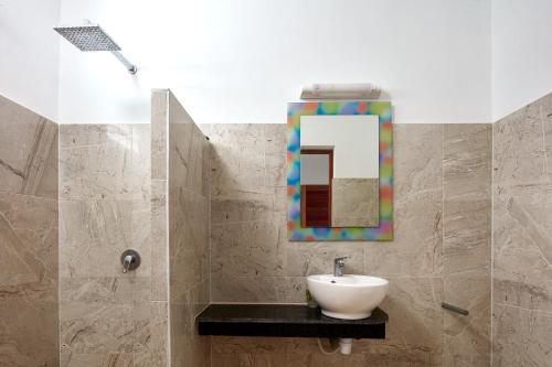 a bathroom with a sink and a mirror at Savane Paille in Deshaies