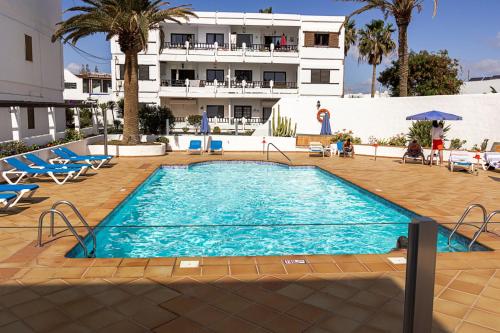 a swimming pool in front of a building at Costa Luz Sirens Beach in Los Pocillos