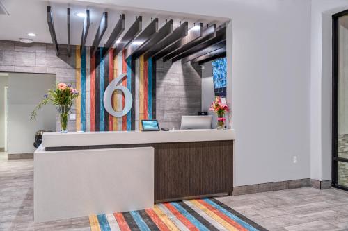an office lobby with a reception desk with a large number six at Studio 6 Suites Stockton, CA Waterfront in Stockton