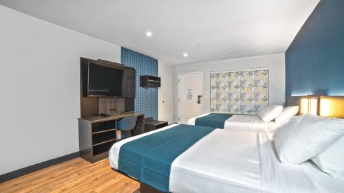a hotel room with a large bed and a television at Studio 6 Suites Stockton, CA Waterfront in Stockton
