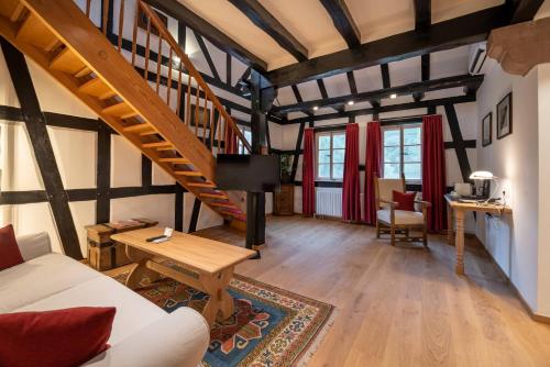 a living room with a staircase and a table at Neumühle Resort & Spa in Hammelburg