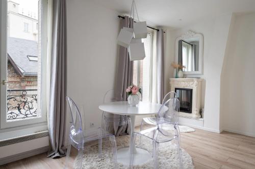 イシー・レ・ムリノーにあるAppartement Design&Nouveau, ParisExpo Pte-de-Versaille, Parking&Netflixの窓付きの客室で、白いテーブルと椅子が備わります。