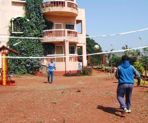 two men playing a game of volley ball in a yard at Quinte Hills Residency in Panchgani
