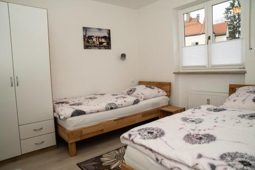 a bedroom with two beds and a window at FeWo Waldi am Kurpark in Bad Tölz