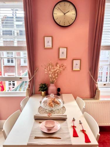 a dining room with a table with a clock on the wall at London Chinatown Apartments in London