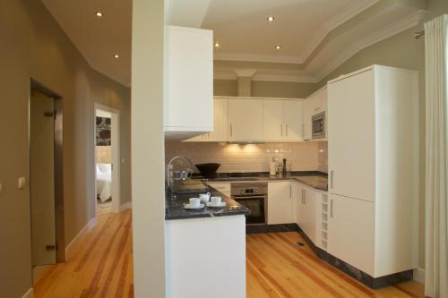 a kitchen with white cabinets and a wooden floor at The Docks in Paul do Mar