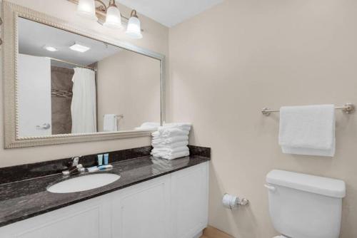 a bathroom with a sink and a mirror and a toilet at Lovely Sandestin Resort Studio with Balcony and Sunset View in Destin