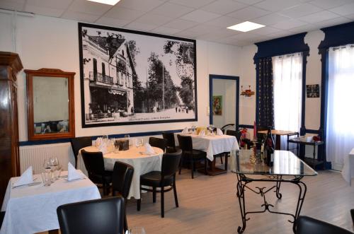 un restaurant avec des tables et des chaises et une grande photo sur le mur dans l'établissement Aux Lys d'Or, à Réalville