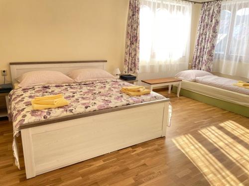 a bedroom with a bed with two yellow towels on it at Chalupa pod Tatrami in Liptovská Teplička