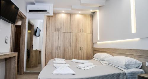 una camera da letto con un letto e asciugamani bianchi di Seaside Luxury Apartments Kremasti a Kremasti