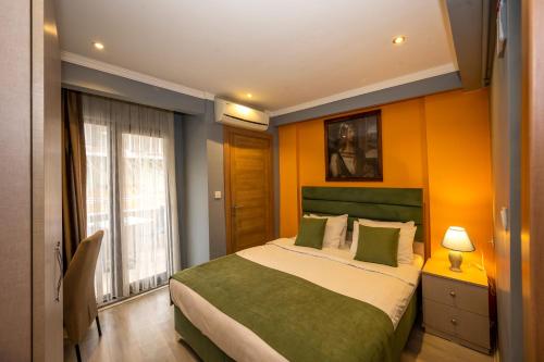 a bedroom with a bed with an orange wall at Istanbul Taksim MARİDA SUIT in Istanbul