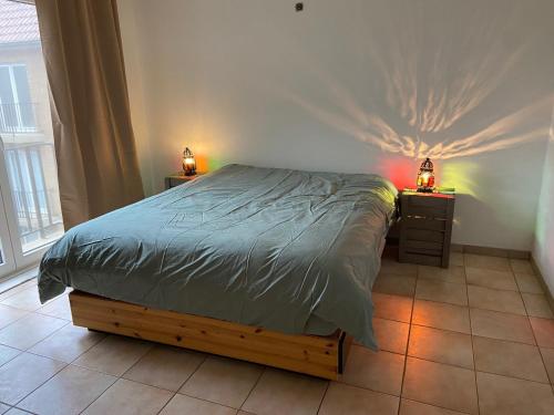 um quarto com uma cama e duas mesas de cabeceira com candeeiros em Ruim zonnig appartement op 50m van strand em Ostend