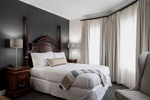 a bedroom with a large bed and a chair at The Federal in Brunswick