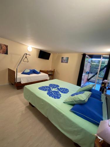 a bedroom with two beds with blue sheets and a window at BORA BORA HOLIDAY'S LODGE in Bora Bora