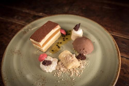 a plate with three pieces of cake and ice cream at Neumühle Resort & Spa in Hammelburg
