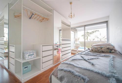 - une chambre avec des murs blancs, un lit et une fenêtre dans l'établissement WAIKIKI-Garage-Terrasse-Fibre-Ensoleillé-Calme-à 10min du centre ville-Clermont-Ferrand, à Chamalières