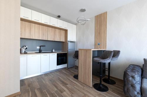 セインツ・コンスタンティン＆ヘレナにあるHelena Holiday Bの白いキャビネットとバースツール付きのキッチン