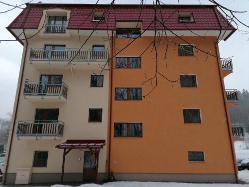 un edificio naranja con techo rojo en Apartmán 68 Horní Lipová en Lipova Lazne